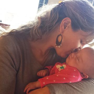 Sarah holding Taryn and kissing her on the cheek.